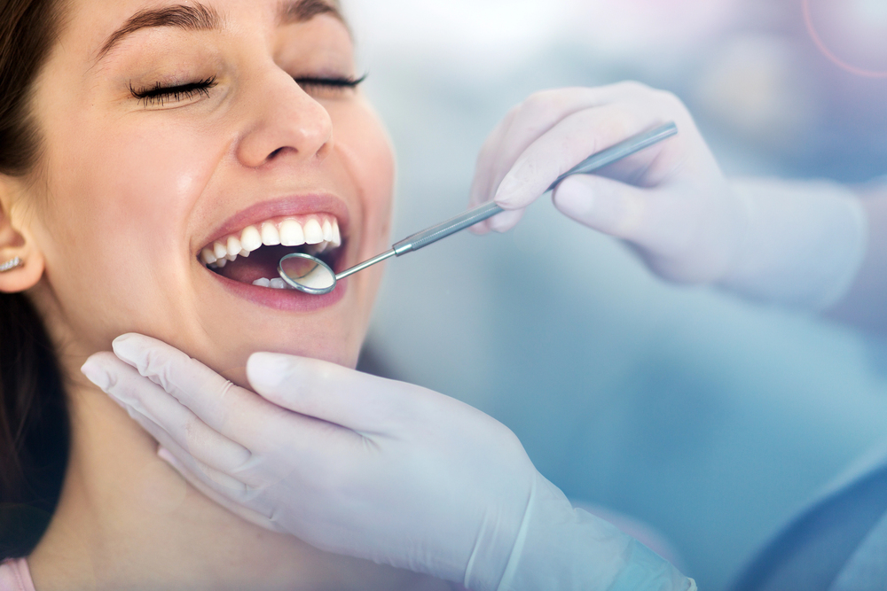 woman at dentist with a dental mirror in mouth