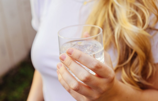 woman holding a glass of water