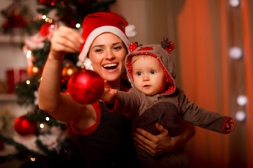 happy mother and son looking at their christmas tree ornament