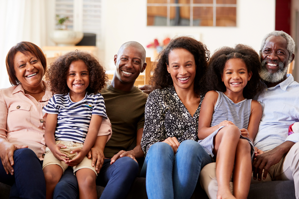 multigenerational portrait of black family sitting on couch in home