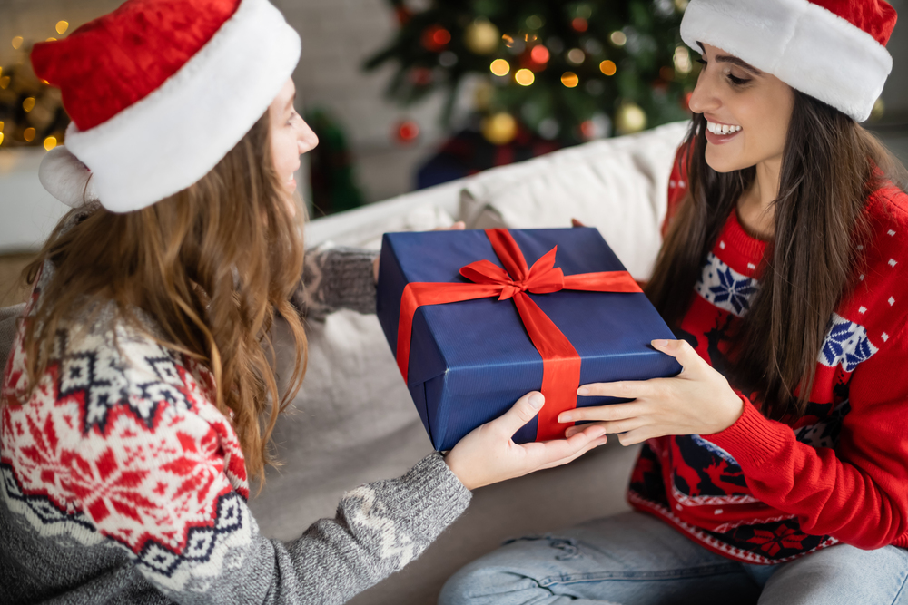 young women exchanging a Christmas gift