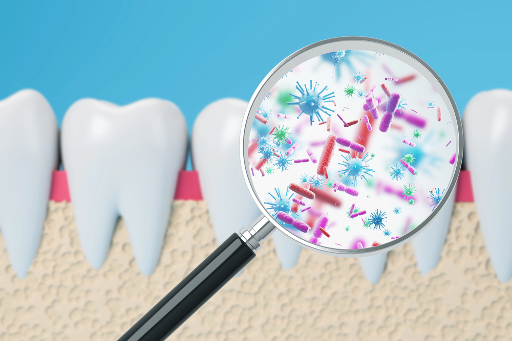 magnifying glass being held up to a tooth, showing microorganisms on tooth